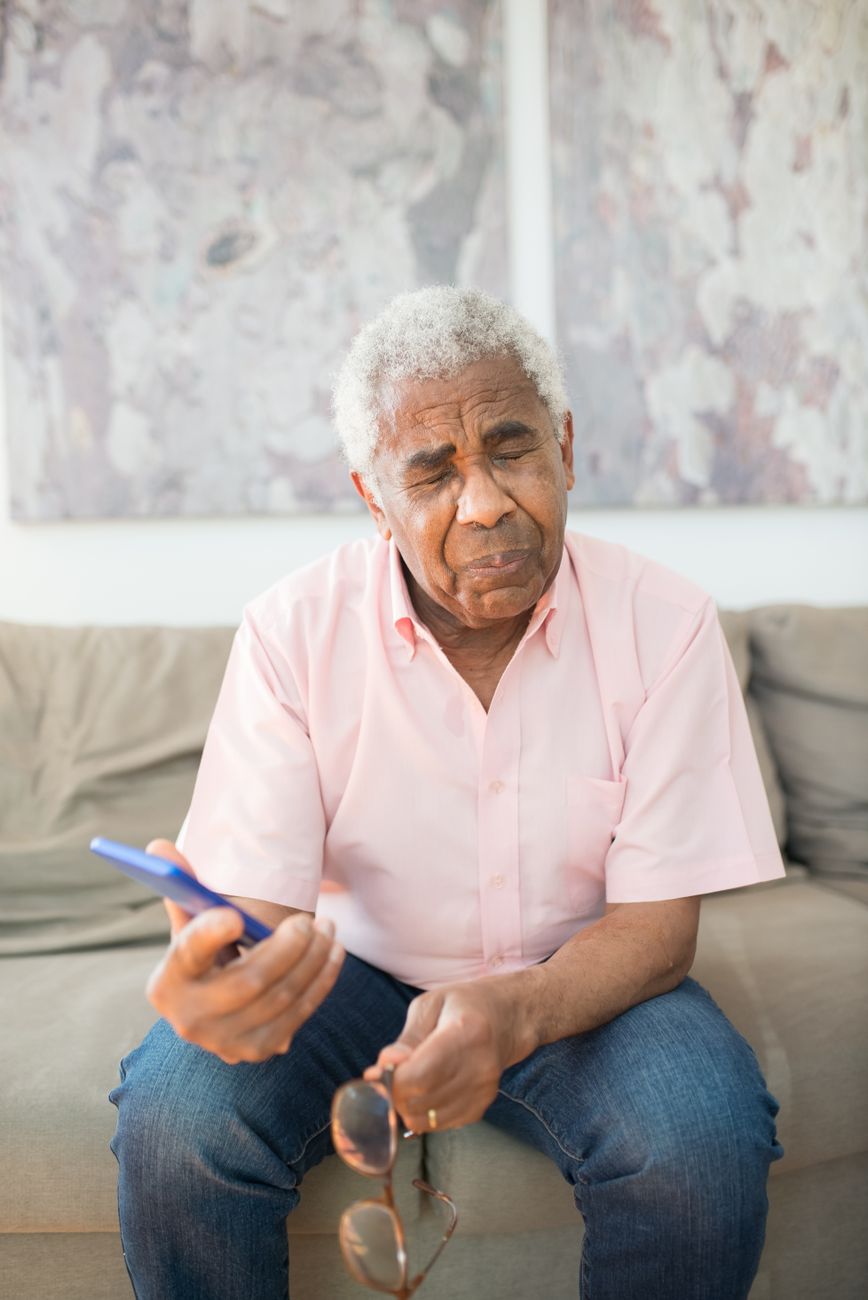 Senior man looking at his phone with frustration